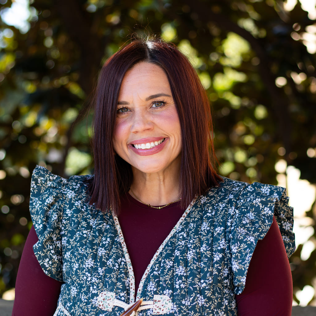 Woman smiling in adorable floral shirt and overalls