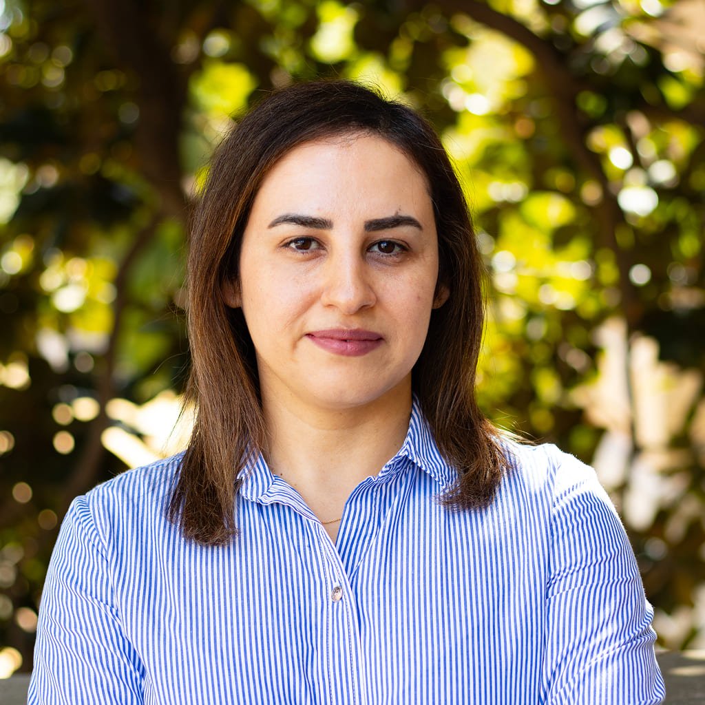 A woman in striped blue and white button-up shirt smiling